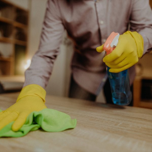 man cleaning solid wooden table
